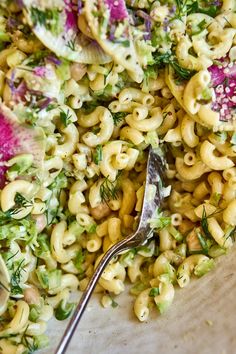 a bowl filled with macaroni salad and a spoon