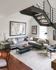 a living room filled with furniture and a stair case