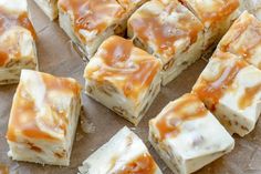 several pieces of dessert sitting on top of a piece of wax paper with caramel toppings