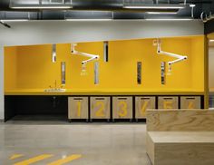 an empty room with yellow cabinets and sinks