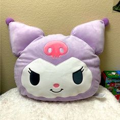 a purple pillow with a pink eye patch on it's face, sitting on top of a pile of candy