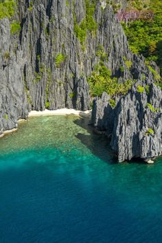 the water is crystal blue and clear with green vegetation on both sides of the cliffs