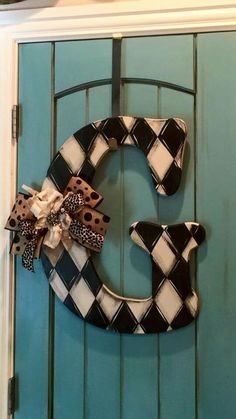 the letter c is decorated with black and white checkered fabric, bow, and leopard print ribbon