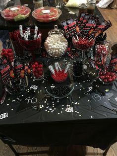 a table topped with candy and candies on top of a black cloth covered table