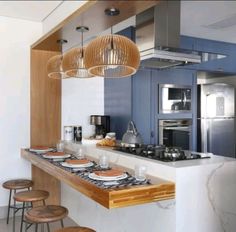 a kitchen with blue cabinets and white counter tops, two stools are in front of the bar