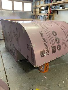 a large roll of pink paper sitting on top of a metal object in a garage