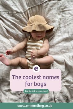 a baby laying on top of a bed wearing a hat