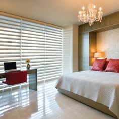 a bedroom with a bed, desk and chandelier