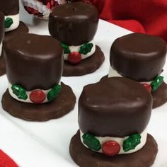 chocolate covered desserts are arranged on a white platter with red and green decorations