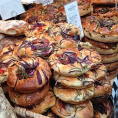 many different types of breads on display at a market