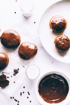 chocolate frosted donuts sitting on top of a white plate