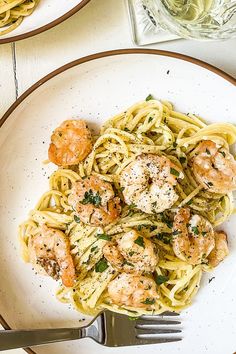 two plates of pasta with shrimp and parmesan cheese