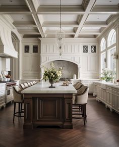 a large kitchen with wooden floors and white cabinets, along with an island in the middle