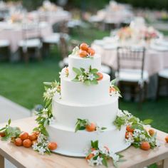 a white wedding cake sitting on top of a wooden table