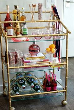 a gold bar cart filled with bottles and glasses