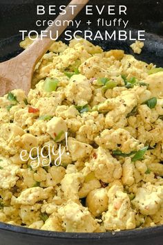 the best ever creamy and nutty tofu scramble in a skillet with a wooden spoon