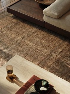 a living room with a couch, coffee table and rug on the floor in front of it