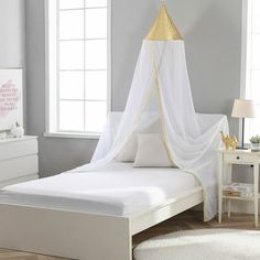 a bed with a white canopy over it next to a dresser and window in a room