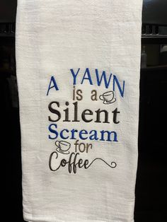 a tea towel with the words a yawn is a silent scream for coffee