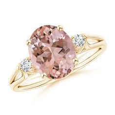 an oval morganite and diamond ring with two diamonds on the band, set in yellow gold