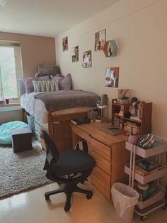 a bedroom with a bed, desk and chair next to a window in the room