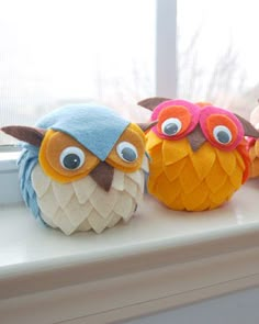 three stuffed owls sitting on top of a window sill