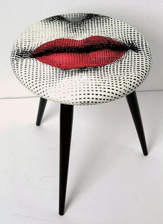 a white and black stool with red lips on it