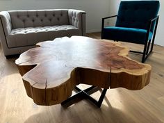 a wooden table sitting on top of a hard wood floor next to a blue chair