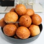 a bowl filled with lots of doughnuts sitting on top of a white table