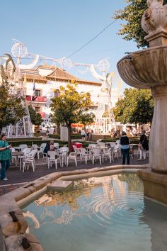 an outdoor fountain with chairs and tables around it