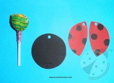 the paper ladybug is next to two black and red tags on a blue background