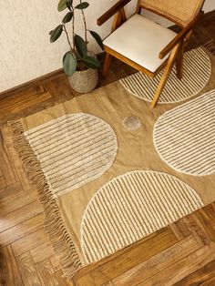 a chair sitting on top of a hard wood floor next to a potted plant