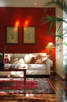 a living room with red walls and white furniture in the center, along with potted plants