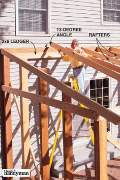 a man standing on top of a wooden frame in front of a house under construction