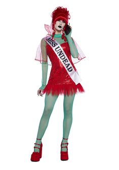 a woman in a red and green costume talking on a cell phone while wearing a tiara