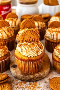 cupcakes with white frosting and cookies on the top are sitting next to each other