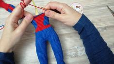 someone is crocheting a spiderman doll with scissors and yarn on the table