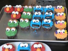 cupcakes made to look like sesame street characters are displayed on a metal tray