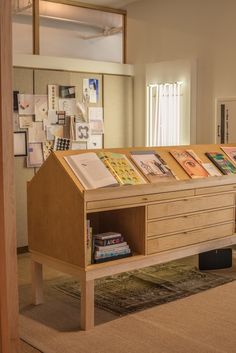 a wooden desk with books on it in a room filled with pictures and other items