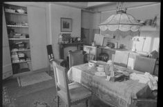 an old black and white photo of a dining room table with dishes on the table