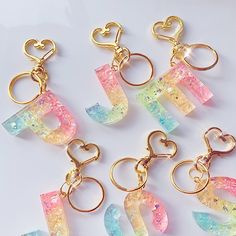 six different colored acrylic key chains with heart shaped charms on each one side