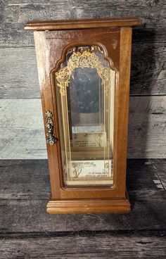 an old wooden grandfather clock sitting on top of a wood floor next to a wall