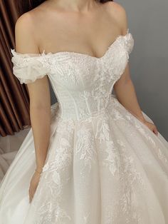 a woman in a wedding dress posing for the camera with her hands on her hips