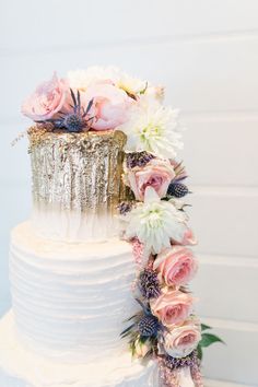 a white wedding cake with flowers on top