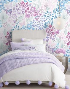 a bedroom with floral wallpaper and pom poms