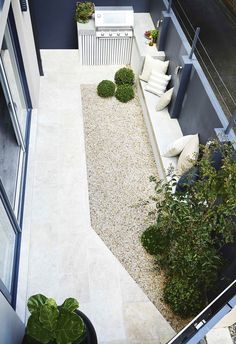 an aerial view of a patio with gravel and plants on the ground, next to a building