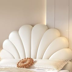 a large white shell headboard on top of a bed