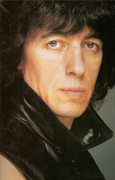 a close up of a person wearing a black leather jacket and looking at the camera