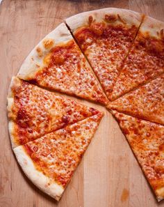 a sliced pizza sitting on top of a wooden cutting board