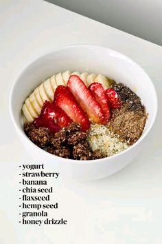 a white bowl filled with granola and sliced strawberries on top of each other